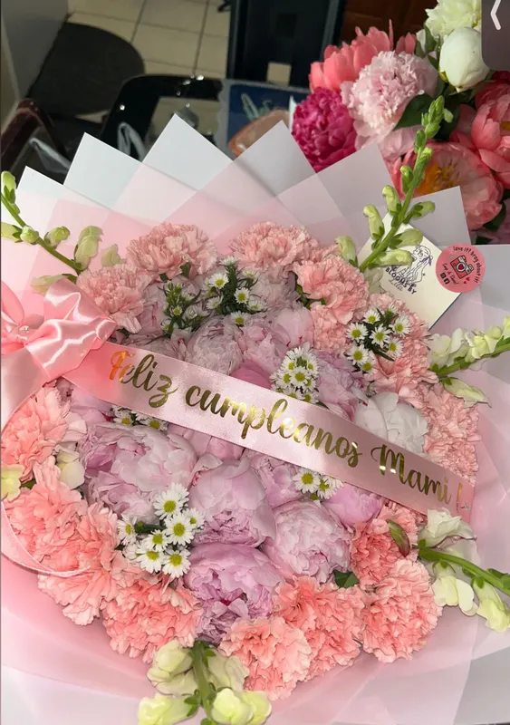 Pink carnation bouquet with a Feliz cumpleaños Mamá sash
