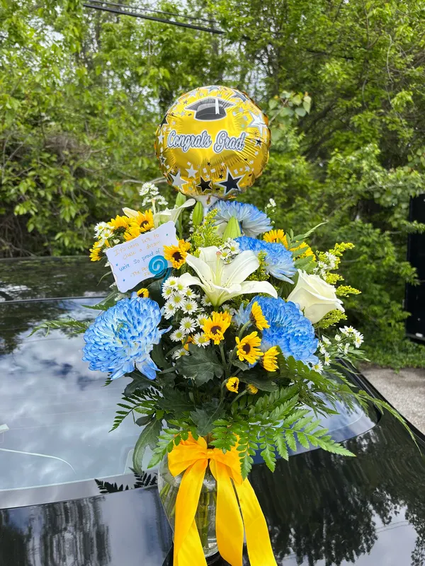 Blue, yellow and white graduation arrangement with a Congrats Grad balloon
