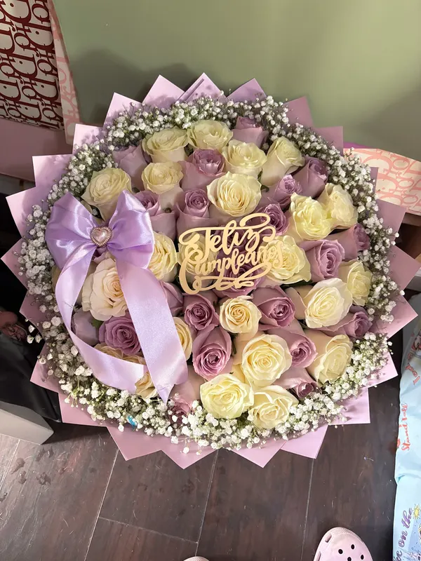 Lilac and cream roses with a lilac bow and gold Feliz Cumpleaños topper