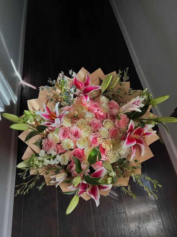 Mixed bouquet of lilies and roses in a kraft wrap