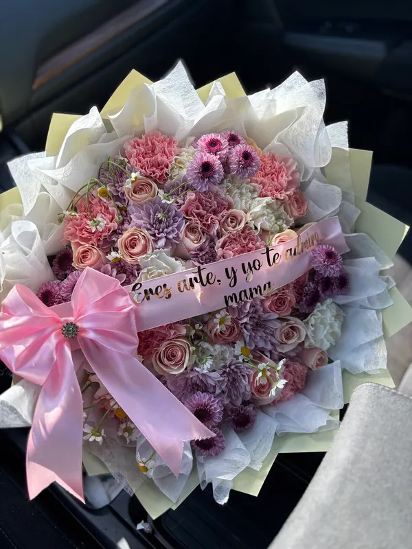 Mauve and pink bouquet with an Eres arte y yo te admiro mamá sash and pink bow