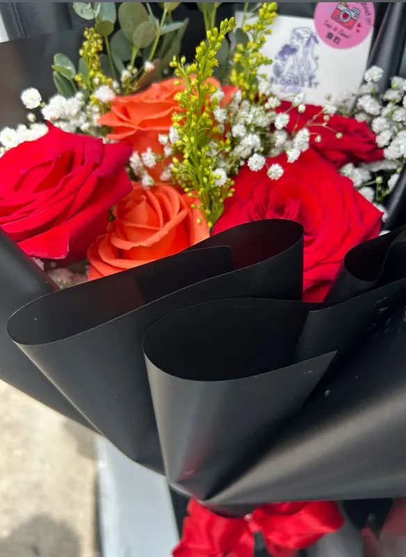 Red and orange roses in a black wrap