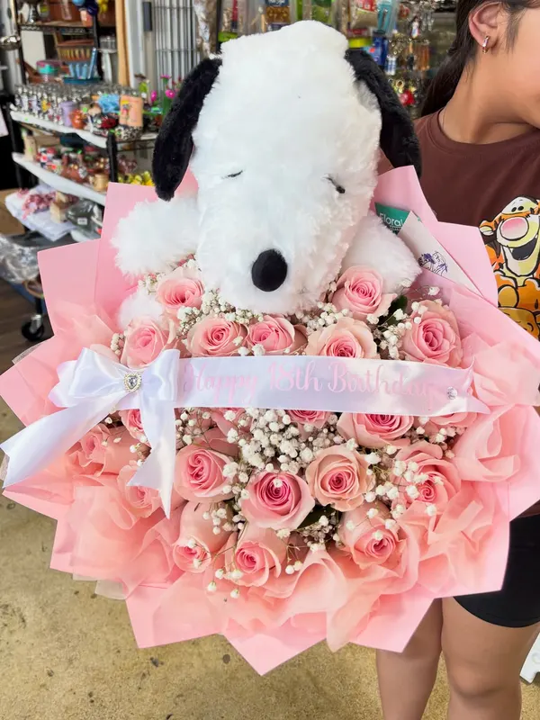 Pink rose bouquet with a Snoopy plush and baby's breath