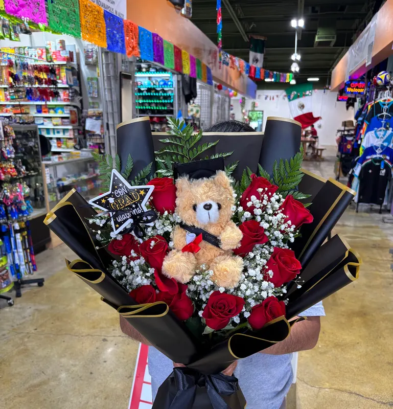 Red roses with a teddy bear in a black wrap